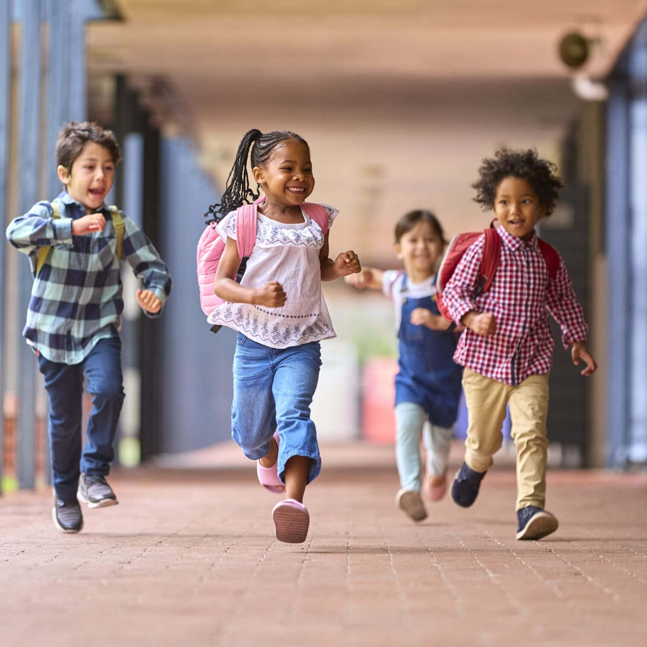 A group of children running in the hallway.